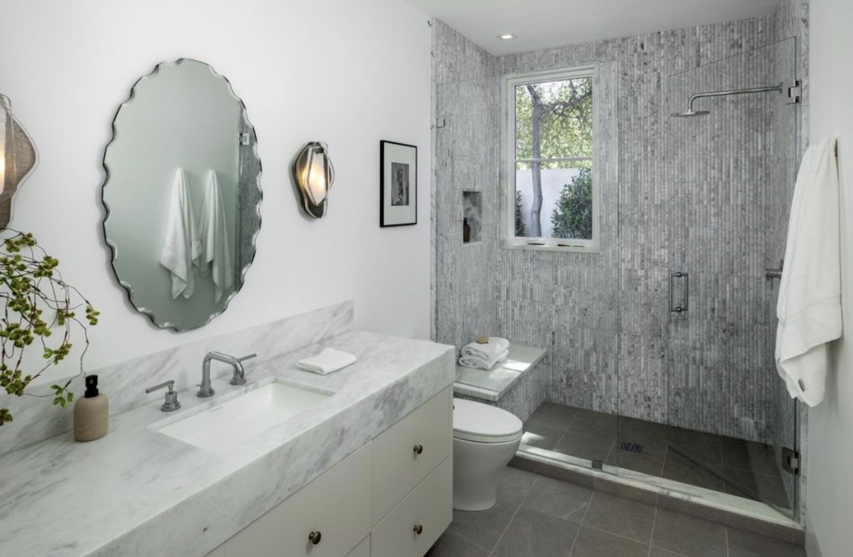 Refined marble bathroom with glass shower and custom vanity