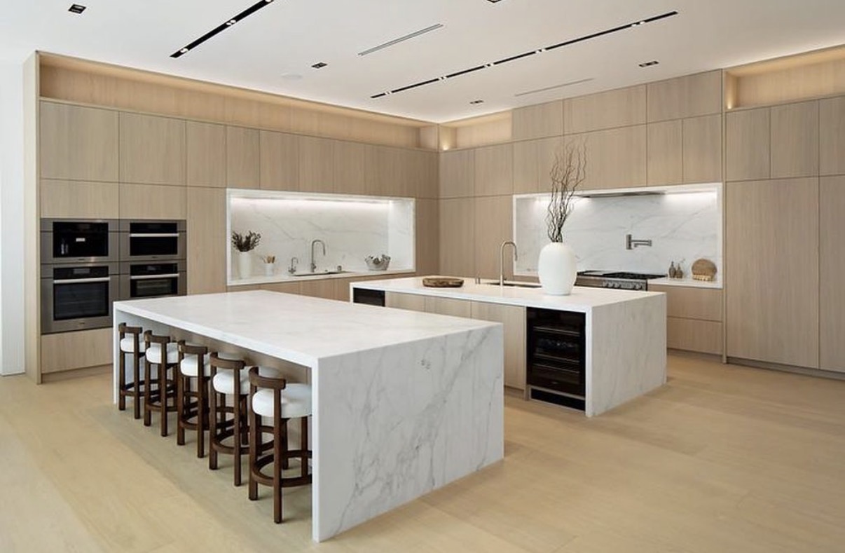 Custom light oak kitchen with waterfall marble islands