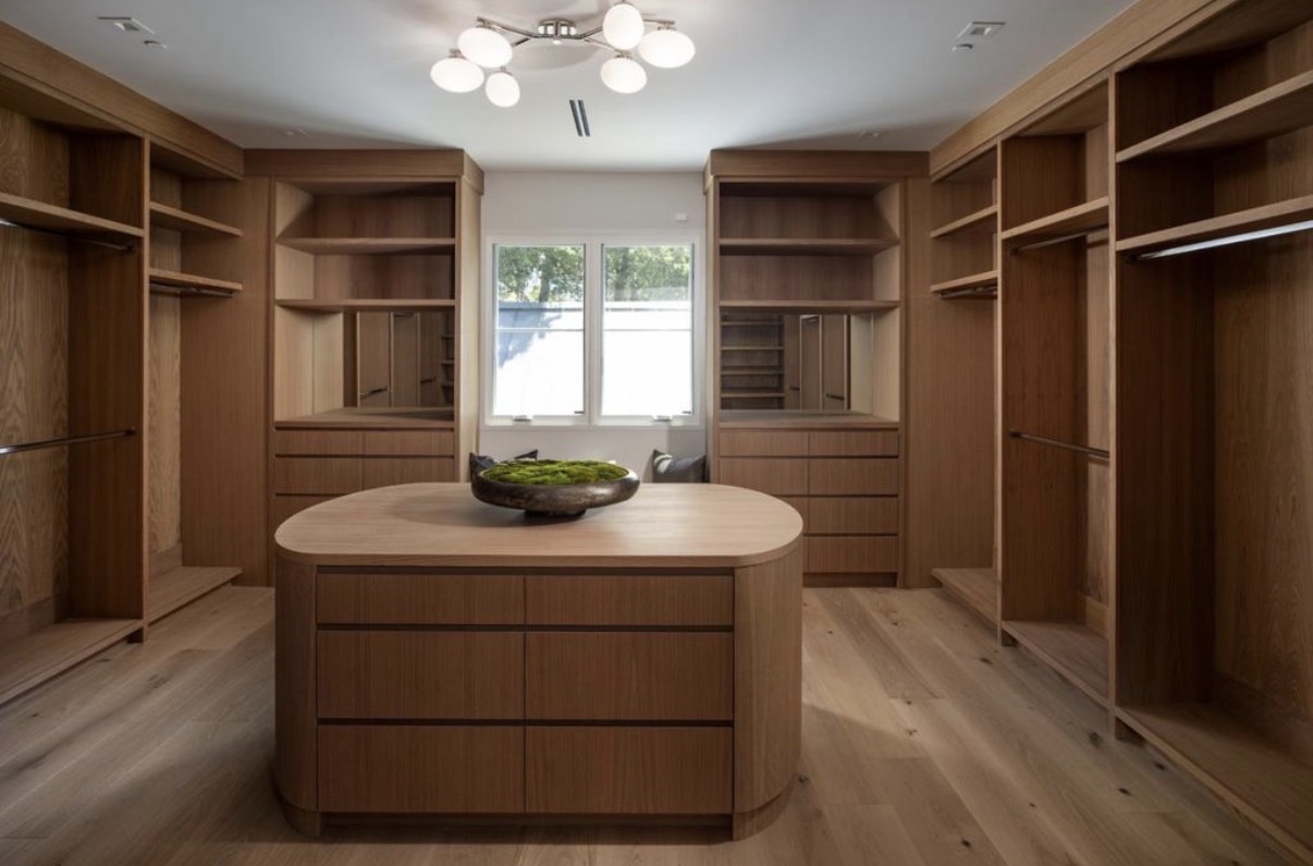 Bespoke walnut dressing room with central island and integrated lighting