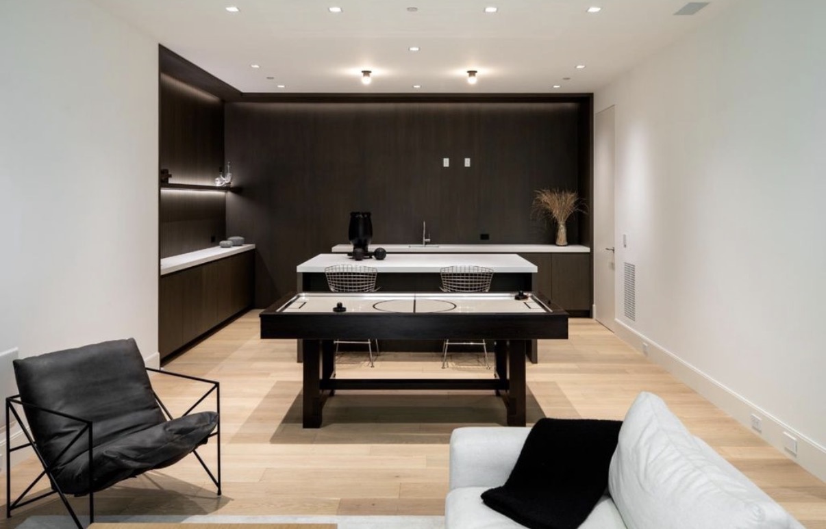 Modern recreation room with integrated cabinetry, wet bar and game table