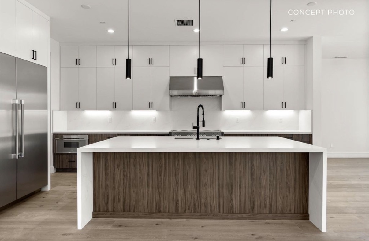 Contemporary white and walnut kitchen with waterfall island and pendant lighting