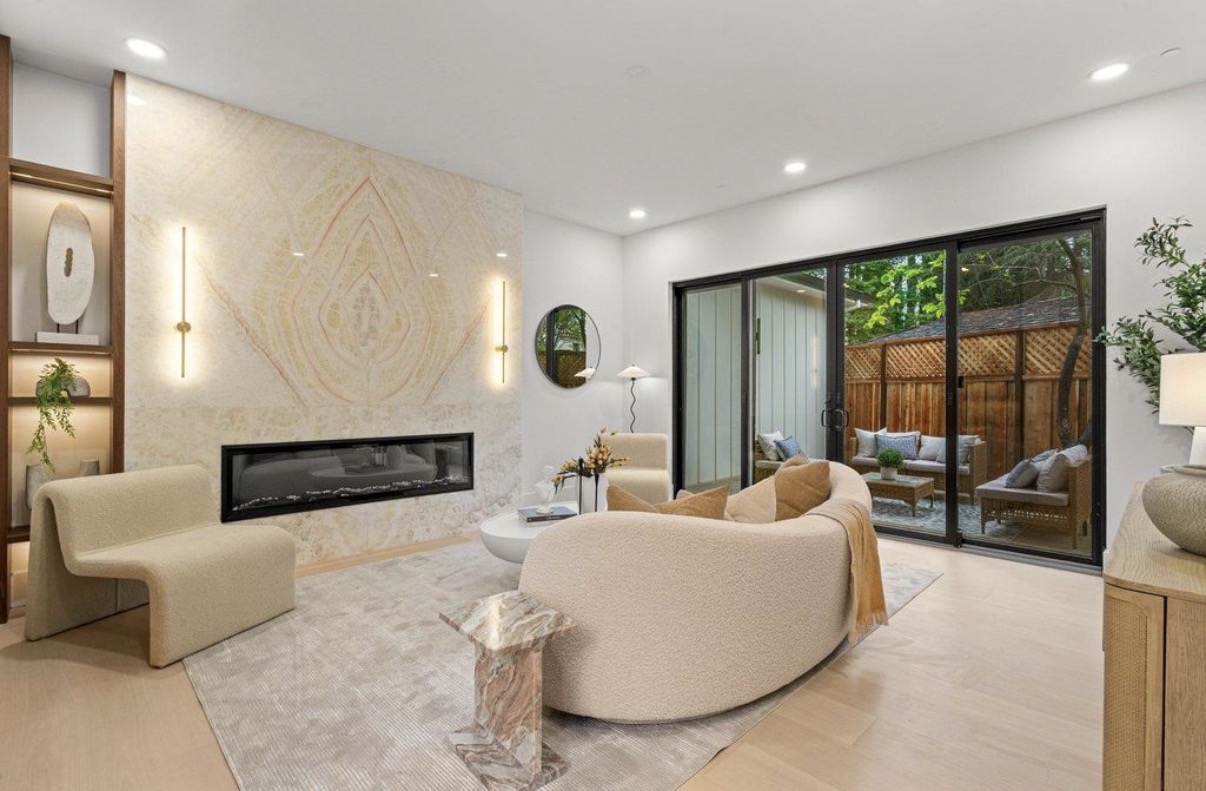 Warm contemporary living room with stone fireplace and garden terrace