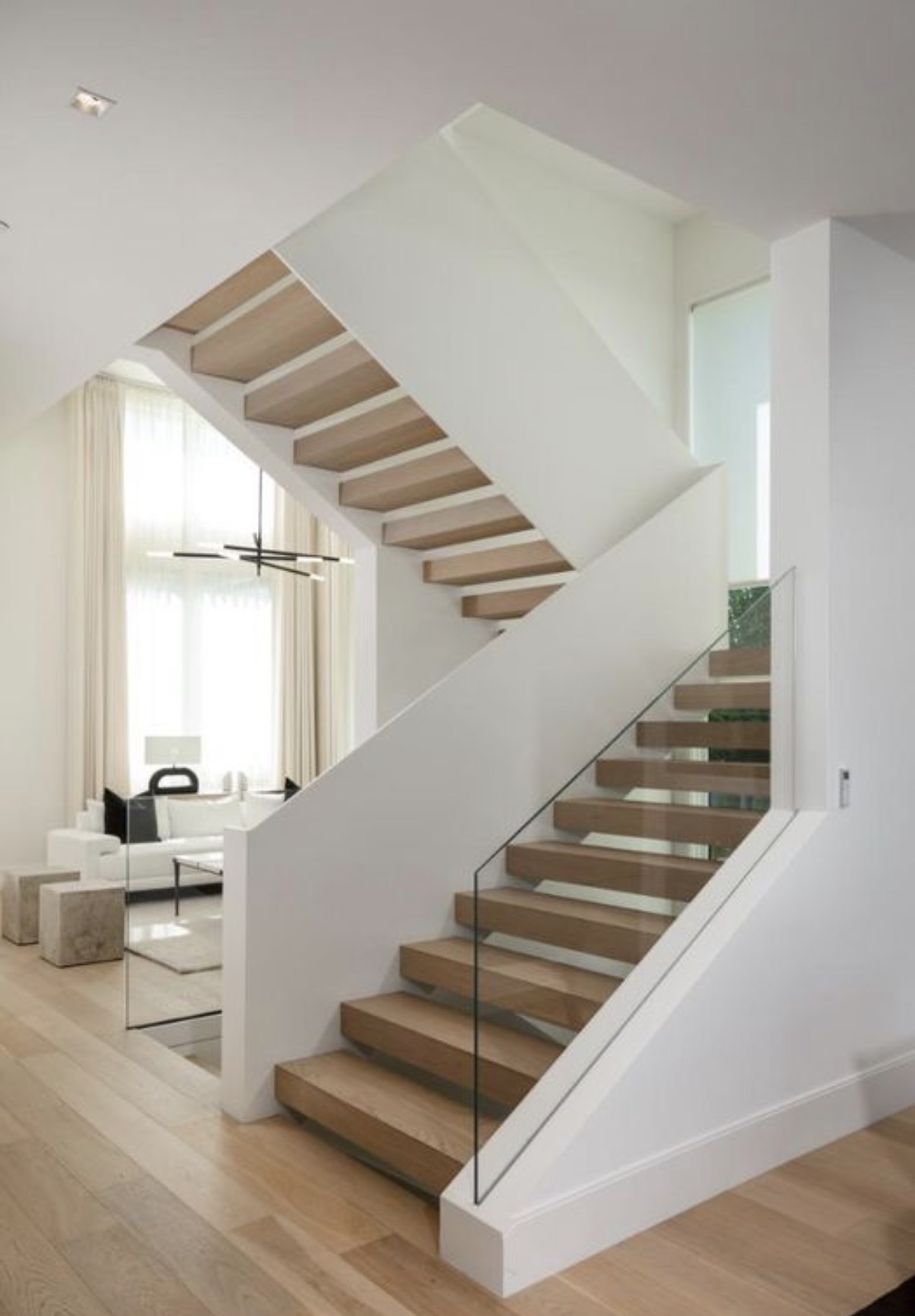 Sculptural floating oak staircase with frameless glass railing